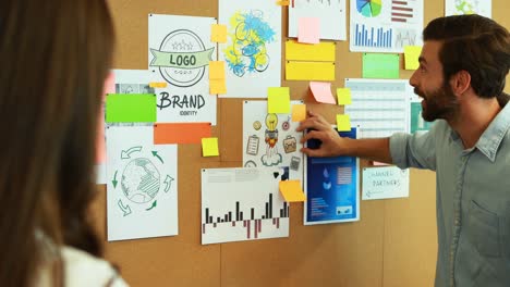 business colleagues discussing over bulletin board