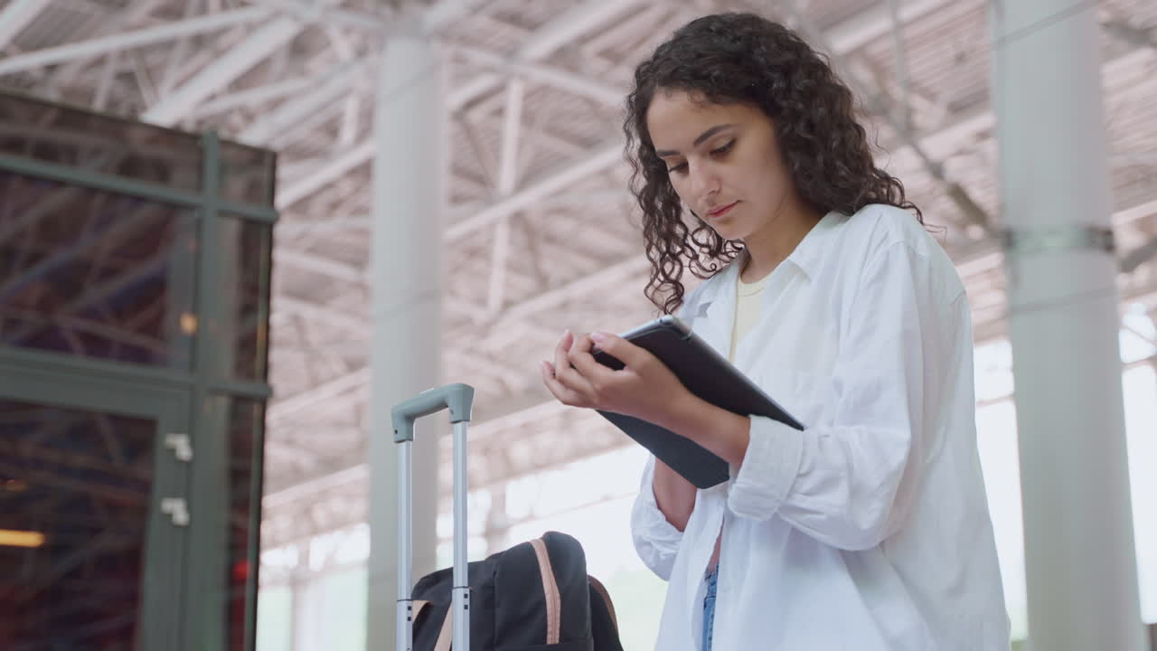 mujer en el aeropuerto comprobando los detalles del vuelo