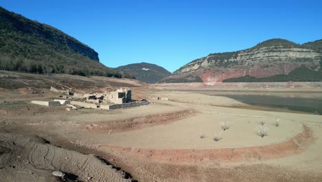 Sau-Sumpfdeich-In-Katalonien,-Spanien,-Intensive-Dürre-Im-Jahr-2024.-Blick-Auf-Die-Ruinen,-Die-Aufgrund-Der-Dürre-Des-Pantano-De-Sau-Freigelegt-Wurden