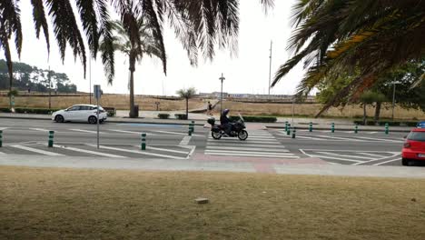 one person runs along the sidewalk and others walk in the background, crosswalk on a cloudy day, shot blocked. porto-novo, galicia, spain