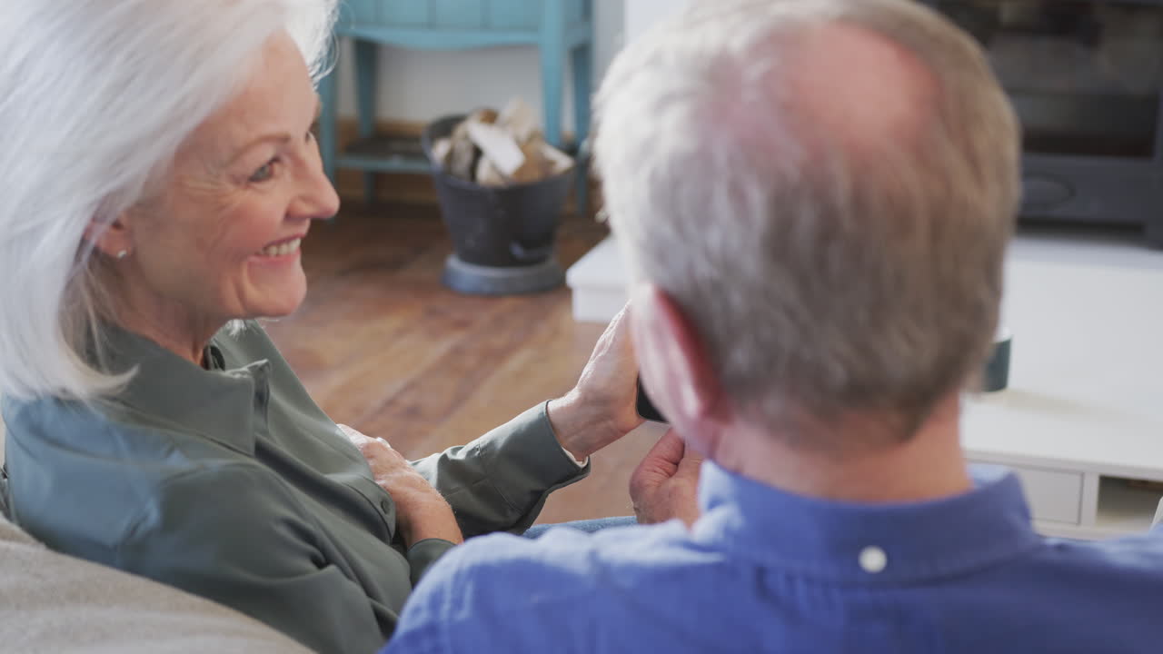 여성 의사가 집에서 디지털 태블릿에서 노인 부부와 비디오 상담을 하고 있습니다.