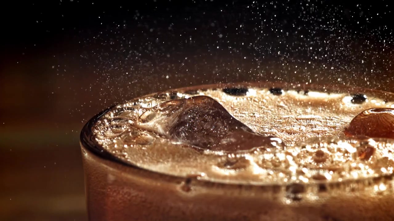Scatto macro di bevanda alla cola effervescente con ghiaccio e bollicine