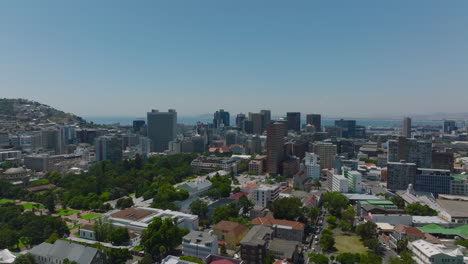 Various-buildings-and-trees-in-town-parks.-Cityscape-with-tall-buildings-and-sea-in-background.-Cape-Town,-South-Africa