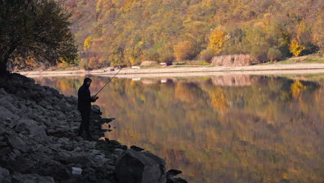 fisherman on the riverbank in autumn