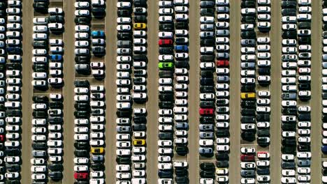 aerial footage of finished cars ready to be shipped on huge distribution center