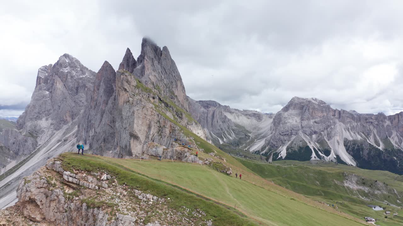 excursionistas en seceda ridgeline con torres fermeda en el fondo, dolomitas, antena