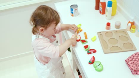 Weibliches-Kleinkind,-Das-Im-Spielzimmer-Einer-Kinderfreundlichen-Cafeteria-Mit-Obstschneidespielzeug-Spielt