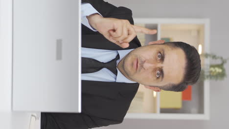 Vertical-video-of-Home-office-worker-man-looking-at-camera-with-a-stern-angry-warning.