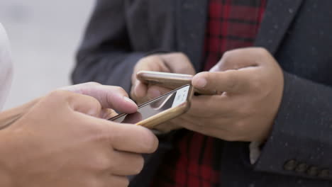 hombre y mujer usando teléfonos celulares