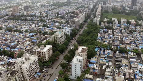 aerial view of vehicles driving between crowded buildings in mumbai suburban district in india