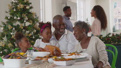 Multi-Generation-Family-Celebrating-Christmas-At-Home-With-Parents-Preparing-Meal-In-Kitchen