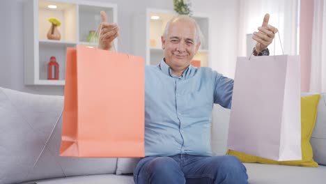 anciano mirando a la cámara con bolsas de compras.