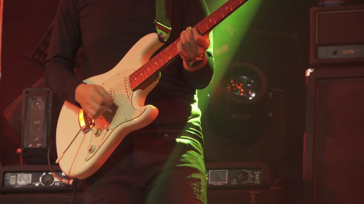 Chitarrista che suona la chitarra elettrica su un palco, esibendosi con musica rock e dal vivo in discoteca, pub, club, bar per una festa, un festival musicale o una performance. Intrattenimento notturno. Evento celebrativo.