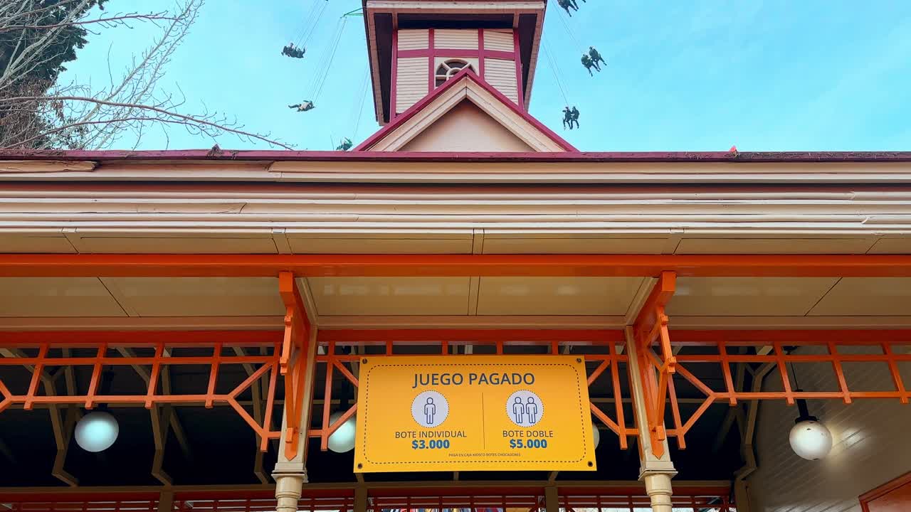 Panoramic tilt up of a private, paid attraction inside the Fantasilandia amusement park in Santiago, Chile on a sunny day.