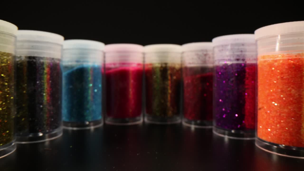 Una serie di vasetti chiusi con glitter per trucco e manicure.