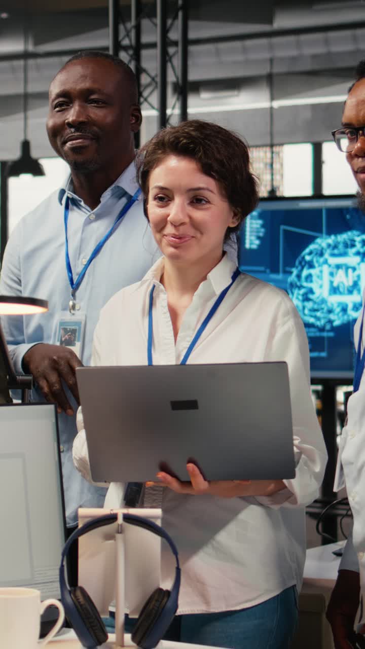 Video verticale con ritratto di un team di ingegneri sorridenti in ufficio che automatizza i workflow usando l'IA