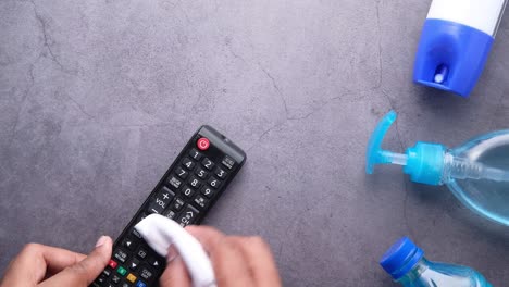limpieza de un control remoto de la tv con suministros de limpieza
