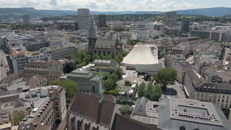 4k drone video of trains and skyline of basel, switzerland with historic buildings, gothic churches, and modern opera house (dolly forward)