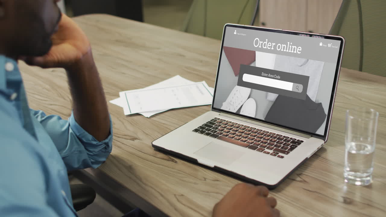 hombre afroamericano usando una computadora portátil, compras en línea de ropa, cámara lenta
