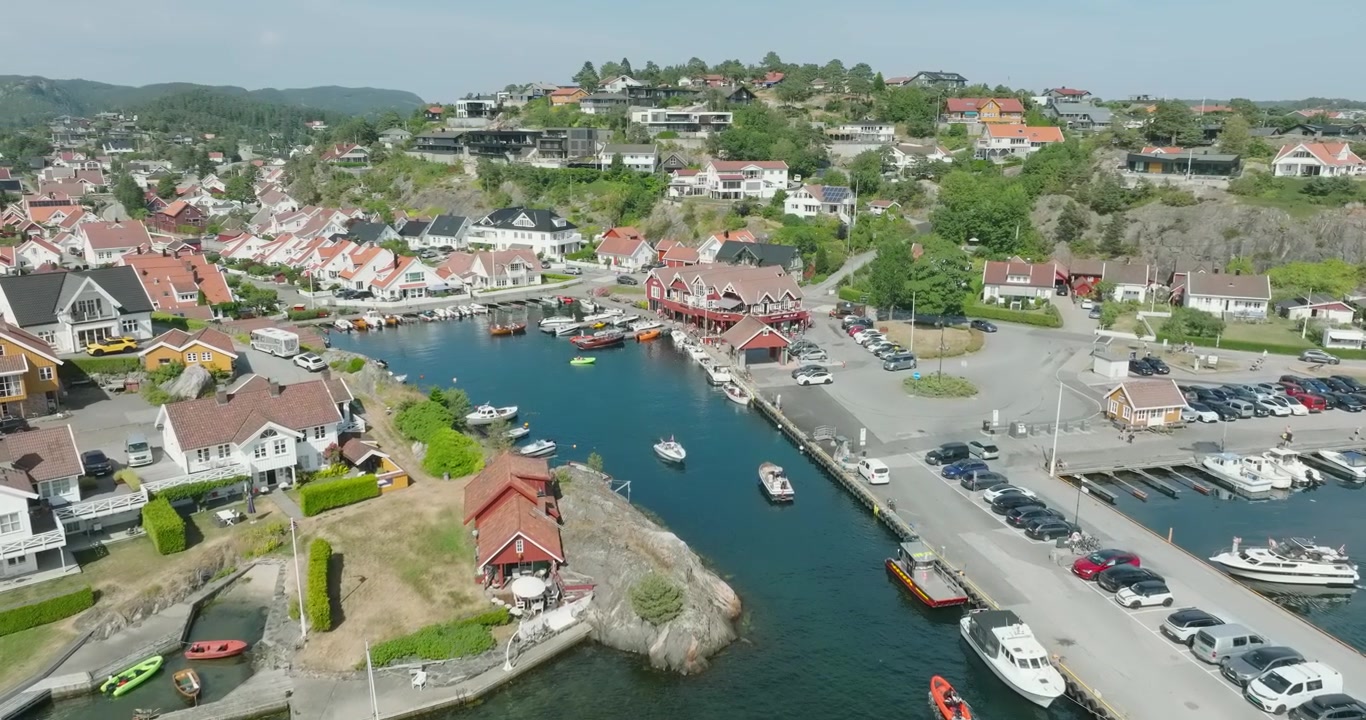 Widok z lotu ptaka na nadmorską marinę i dzielnicę mieszkalną w Høllen w Norwegii w zwolnionym tempie