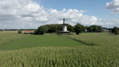 jib up of rotating windmill surrounded by green meadows