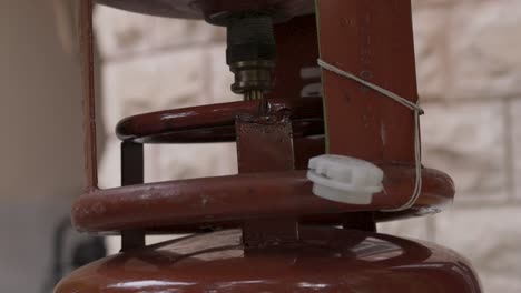 relleno de cilindros de gas de petróleo licuado a través de una válvula en una tienda minorista durante el día