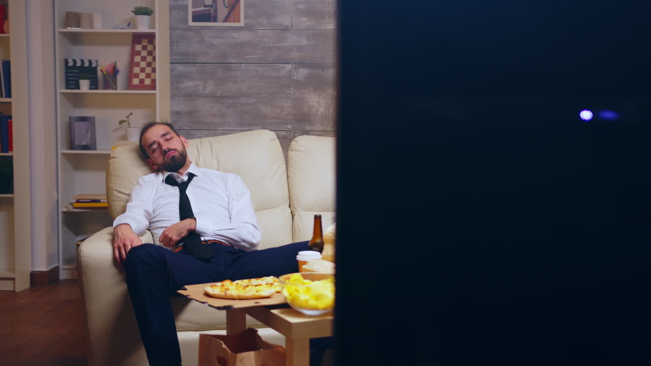 Young businessman in suit falling asleep on the couch