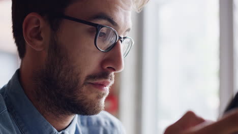 Man-using-digital-display-touchscreen-tablet-ipad-device-in-cafe