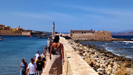 people on the walkway of defkalionos defensive wall in chania, greece. aerial slow motion shot