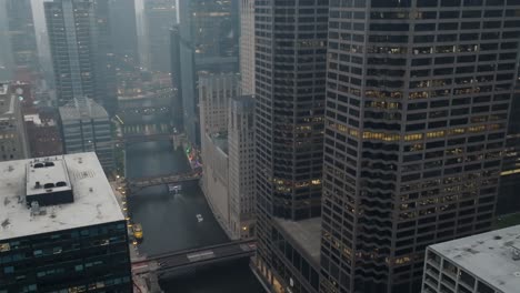 chicago river with skyline of city lit up at dusk