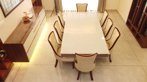 modern dining room interior in an indian home with elegant wooden furniture, dining table, cushioned chairs, sideboard, warm lighting, and stylish decor. contemporary lifestyle and home design