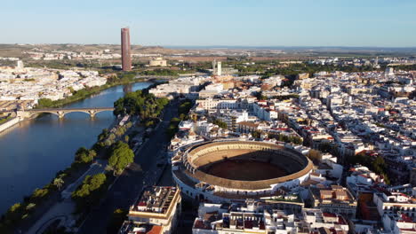 Panoramic-aerial-view-over-Plaza-de-Toros-and-Guadalquivir-River,-Seville