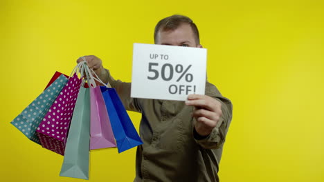 hombre mostrando hasta un 50 por ciento de descuento en inscripciones y bolsas de compras, disfrutando de descuentos. viernes negro