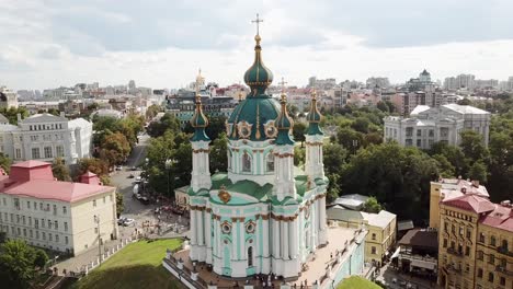 ukraine, kyiv's famous st.andrew church's drone footage on a summer day with cloudy skies. footage zooms out and turns around the church from a perfect angle, streets around the church also visible.