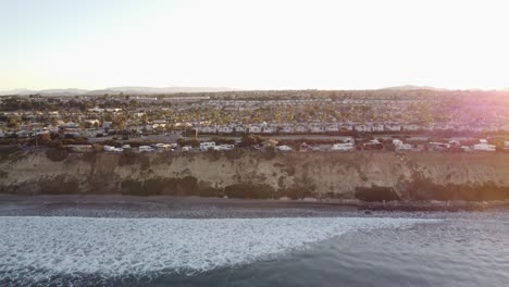 un hermoso disparo aéreo de drones, drones ascendiendo y revelando una ciudad con palmeras y montañas en el fondo, carlsbad state beach - california