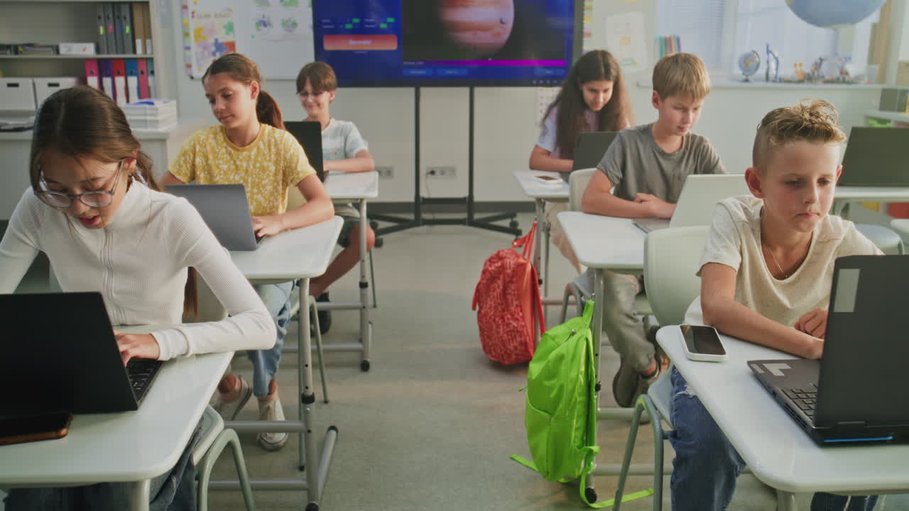 Elementary School Children Using Laptops Creating Drawings During Digital Art Lesson Top View