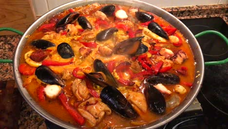 cooking seafood paella at home, traditional spanish paella with prawns, mussels and fish