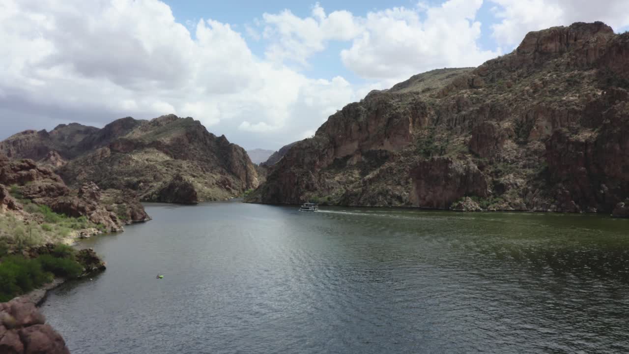 Ferry boat floats past southwestern mountains