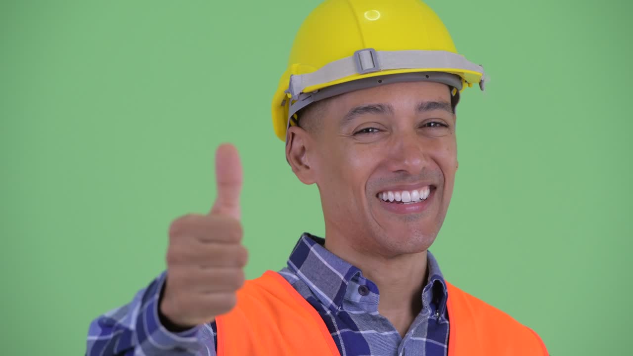 잘생긴 다민족 남성 건설 노동자 미소 짓고 엄지손가락을 올리고