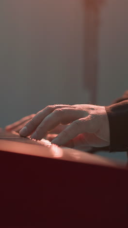 bajo la vista de la mano de un tecladista tocando un sampler. el enfoque está en los movimientos intrincados y la interacción táctil con las teclas, contra un fondo suavemente iluminado