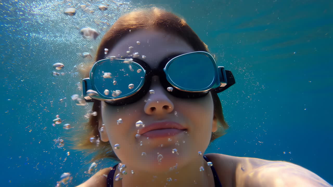 Person underwater wearing swim goggles with bubbles