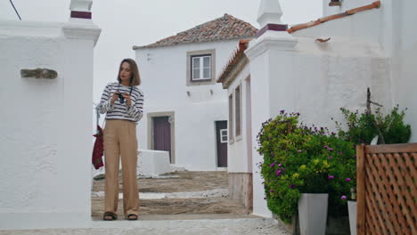 Tourist-girl-stroll-old-mediterranean-city-vertical.-Photographer-check-pictures