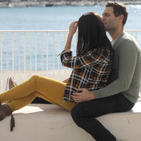 Loving-young-couple-relaxing-at-the-waterfront