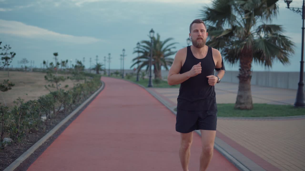 hombre corriendo por un camino costero