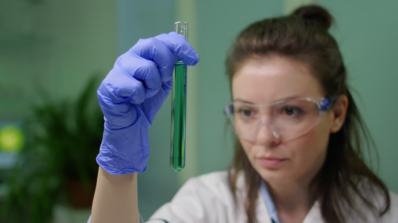 Closeup of scientist woman looking at test tube with dna sample