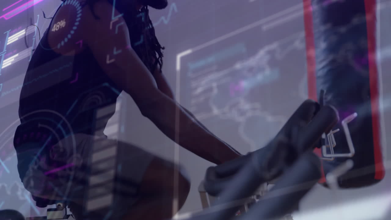 Mature man riding exercise bike indoors, displaying workout progress charts and map outlines