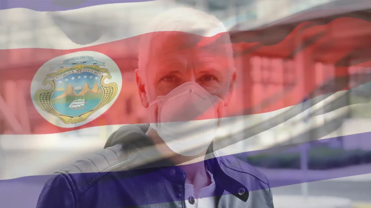 코스타리카 발을 흔들고 있는 코카시안 남성의 초상화가 거리에서 얼굴 마스크를 착용하고 있습니다.