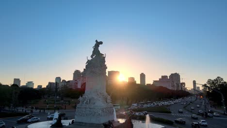 Toma-Aérea-Del-Monumento-De-Mármol-De-Carrara-Carta-Magna-Y-Cuatro-Regiones-De-Argentina-En-La-Intersección-Con-Tráfico-Pesado-Y-El-Horizonte-De-La-Ciudad-De-Palermo-En-El-Fondo