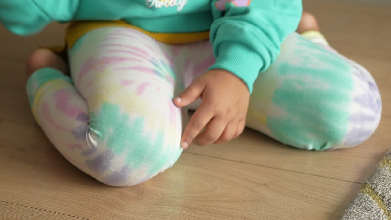 niño sentado en el suelo con leggings de teñido