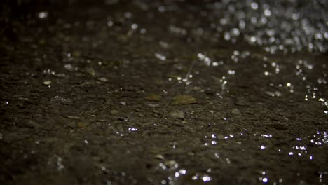 lluvia en la carretera de asfalto por la noche, bucle de fondo de primer plano